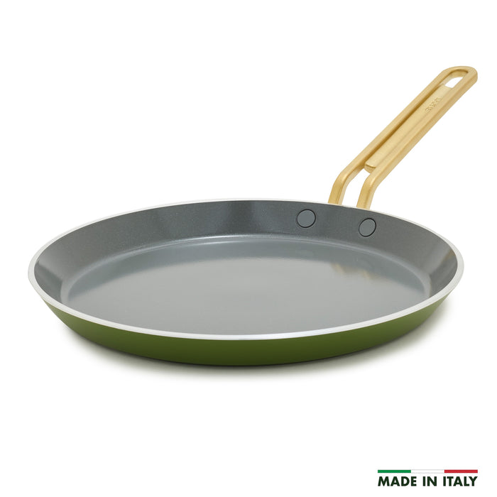 Green crepe pan with a gold handle on a white background