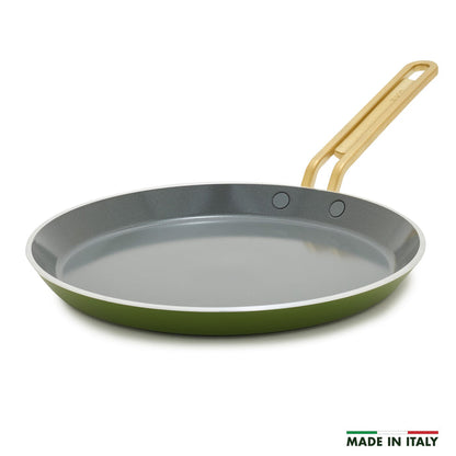 Green crepe pan with a gold handle on a white background