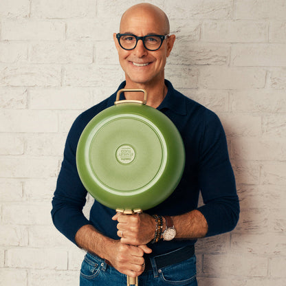 Man with glasses holding a green ceramic 12-inch frypan with lid.