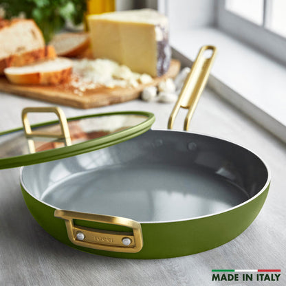 Ceramic nonstick 12-inch frypan with lid in green and gold handles, on a counter beside bread and cheese.
