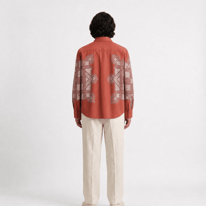 Man wearing the red Terra Rangoli shirt with cream trousers, full length back view