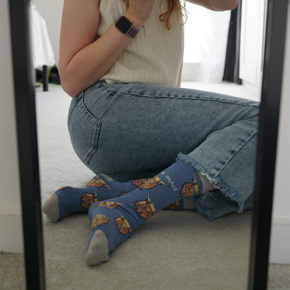 Model wearing highland cows bamboo socks in front of mirror