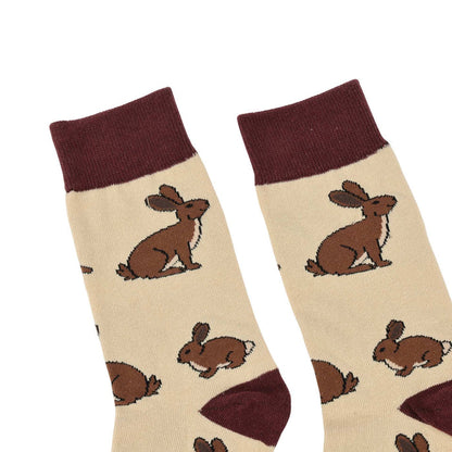Pair of socks with brown hare illustrations on a beige background