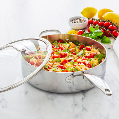 Stainless steel sauté pan with lid, 5-quart size, with pasta, tomatoes, basil, and cheese on a marble countertop.